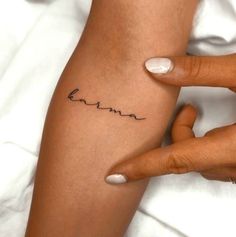 a woman's arm with the word love tattooed on her left side, in cursive font