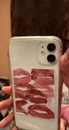 someone is holding up their phone case with lipstick prints on it