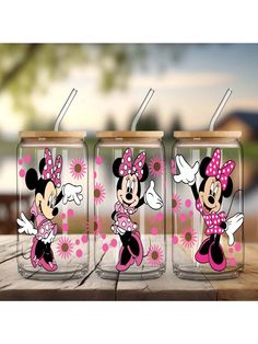 three minnie mouse tumblers sitting on top of a wooden table