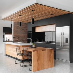 a modern kitchen with an island and bar stools