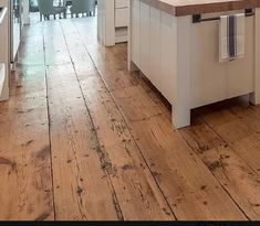 an open kitchen with wooden floors and white cabinetry on the walls is shown in this image