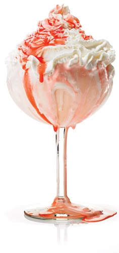 an ice cream sundae with whipped cream and strawberry syrup on it's rim