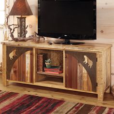 a wooden entertainment center with an animal motif on the front and side panels, along with a lamp