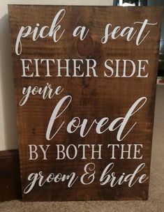 a wooden sign that says pick a seat either side you're loved by both the groom and bride