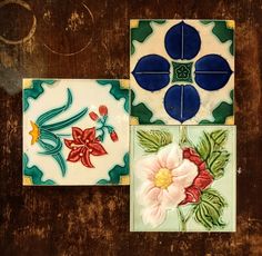 three tiles with flowers painted on them