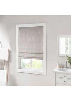 a bathroom with a sink, mirror and window coverings in shades of light gray