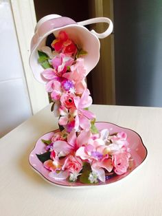 pink and white flowers are in the center of a plate on top of a table