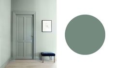 an empty room with a blue chair in the corner and a light green painted door