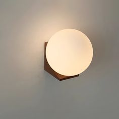 a light that is on the side of a wall with a white ball attached to it