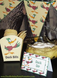 a table topped with a cake next to a bottle of liquid and a sign that says duck bills