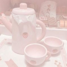 a pink tea set sitting on top of a table