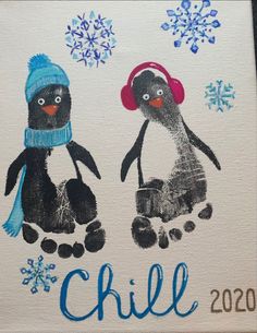 two penguins with hats and snowflakes on their faces are shown in this handprint