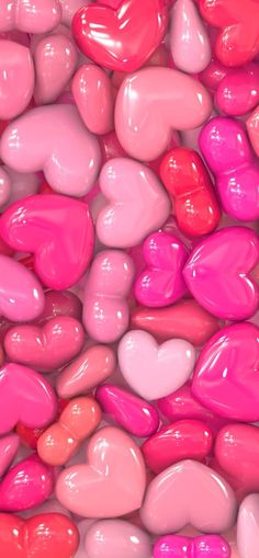 many pink and red hearts are arranged in the shape of heart - shaped candies