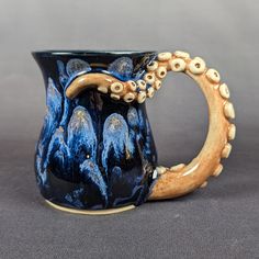 an octopus coffee mug is decorated with blue and white designs on the outside, and inside