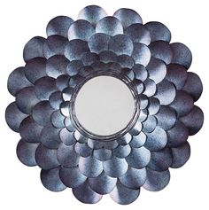 a circular mirror made out of metal discs on a white background with reflection in the center