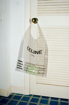 a plastic bag hanging from the side of a door with an ad for celline on it