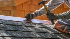 a man is working on the roof of a house with a hammer and naildriver