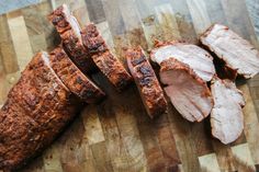 sliced meat sitting on top of a wooden cutting board