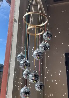 a chandelier with disco balls hanging from it's sides in front of a window