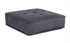 a grey square ottoman with buttons on it