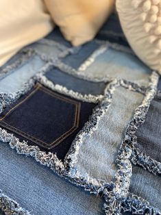 an old pair of blue jeans with holes and fraying on the bottom, sitting on top of a bed