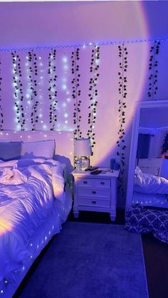 a bedroom decorated in purple and white with string lights