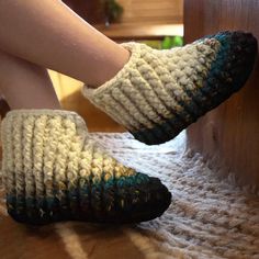 a woman's feet with crocheted slippers on