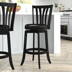 two black bar stools in a white kitchen