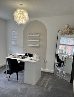 a room with a mirror, desk and chairs in it next to a wall mounted shelf