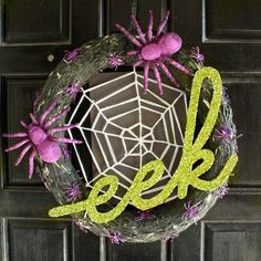 a wreath with spider decorations on it and the word geek spelled out in green letters