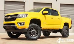 a yellow truck parked in front of a garage door