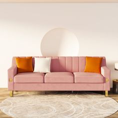 a pink couch sitting on top of a wooden floor next to a white round wall