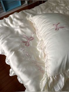 two white pillows with pink bows on them