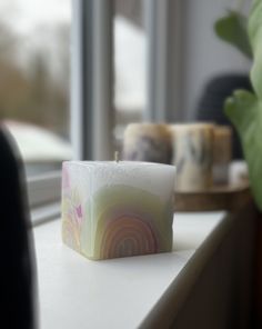 a candle sitting on top of a counter next to a potted plant