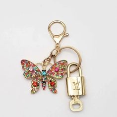 a keychain with a butterfly on it and a padlock attached to it