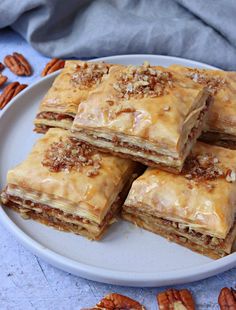 several pieces of pecan pie on a plate with pecans scattered around the edge