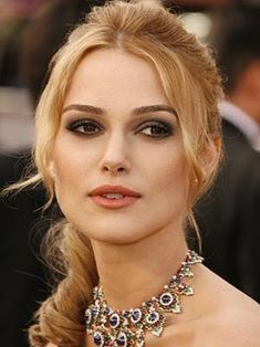 a woman with long blonde hair wearing an elaborate necklace and diamond necklace on her neck