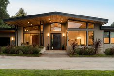 a modern house with large windows and lots of plants