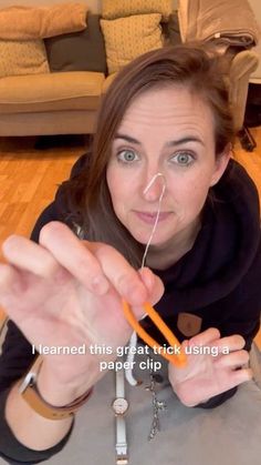 a woman sitting on the floor holding an orange toothbrush