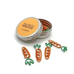 three tins with carrot shaped cookie cutters next to each other on a white surface