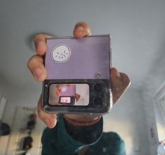 a person holding up a small camera in front of their face