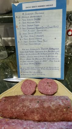 two sausages on a yellow plate next to a sign with instructions for making salami sauce