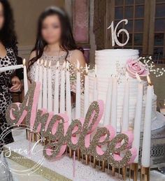 two women standing in front of a cake with candles and the word sparkle on it