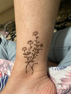 a small flower tattoo on the ankle