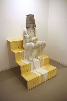 a white statue sitting on top of wooden steps