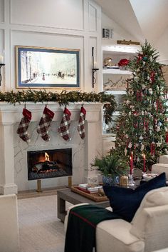 a living room decorated for christmas with stockings on the fireplace