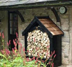 a dog house made out of logs with a clock on the wall