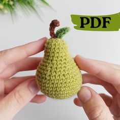 a hand holding a small crocheted pear with the word pdf above it