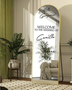 a large mirror sitting on top of a floor next to a chair and potted plant