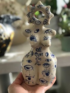 a hand holding up a ceramic sculpture with all eyes are on it